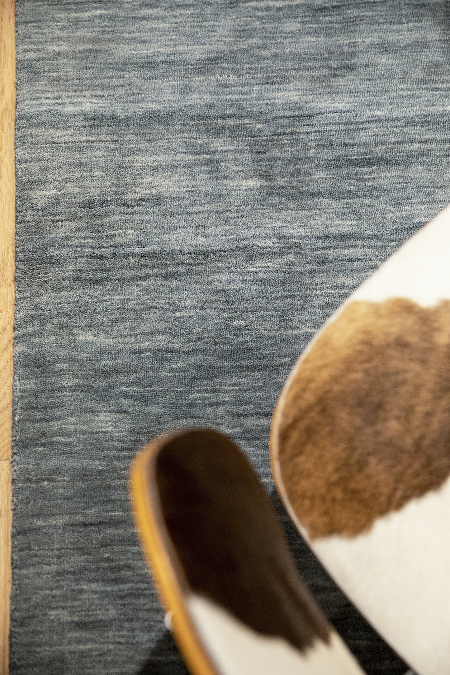 Blue textured area rug on wood floor in a cozy living room.