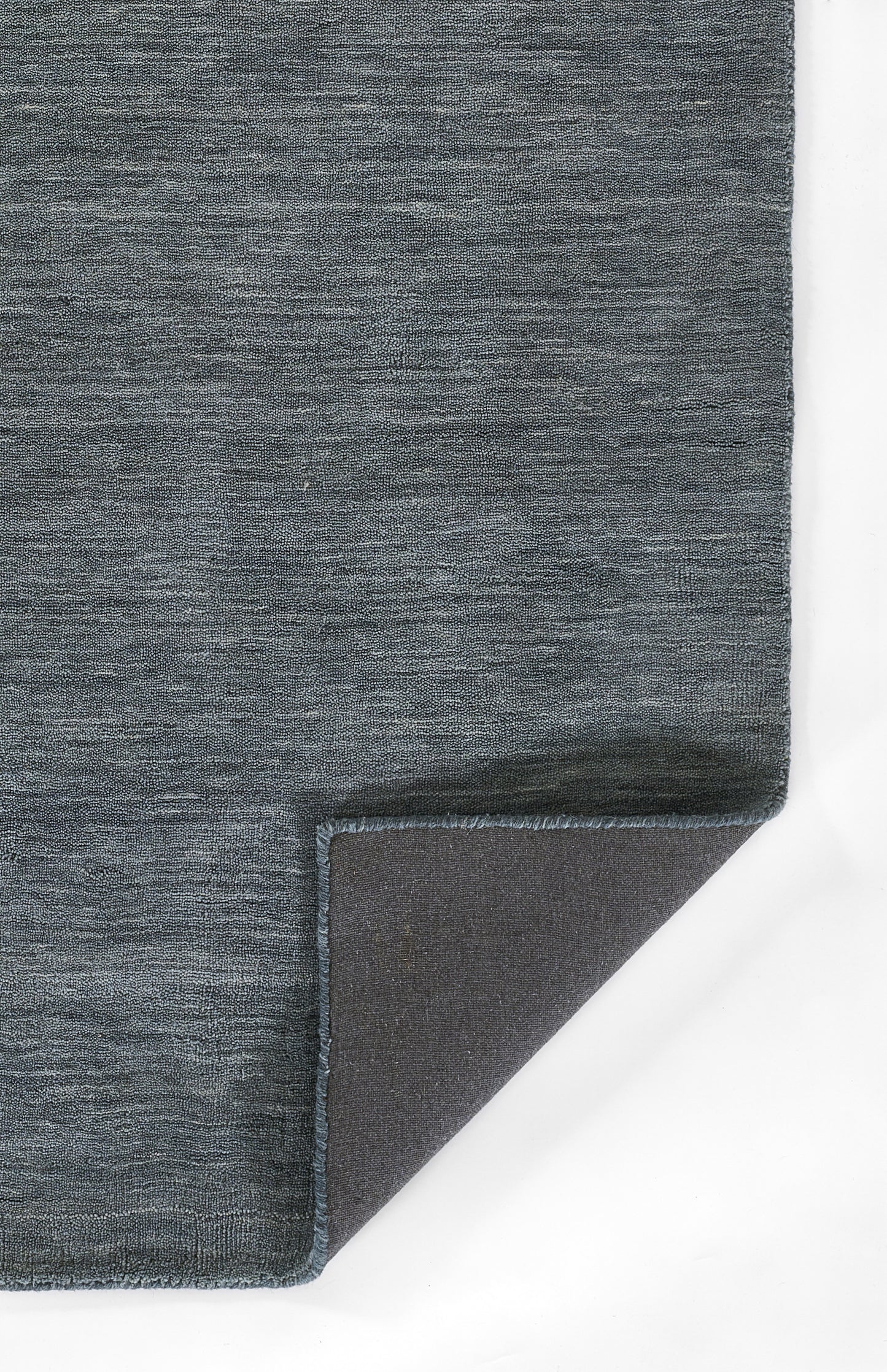 Blue-gray woven rug with textured surface and frayed edge; corner folded to reveal dark underside.