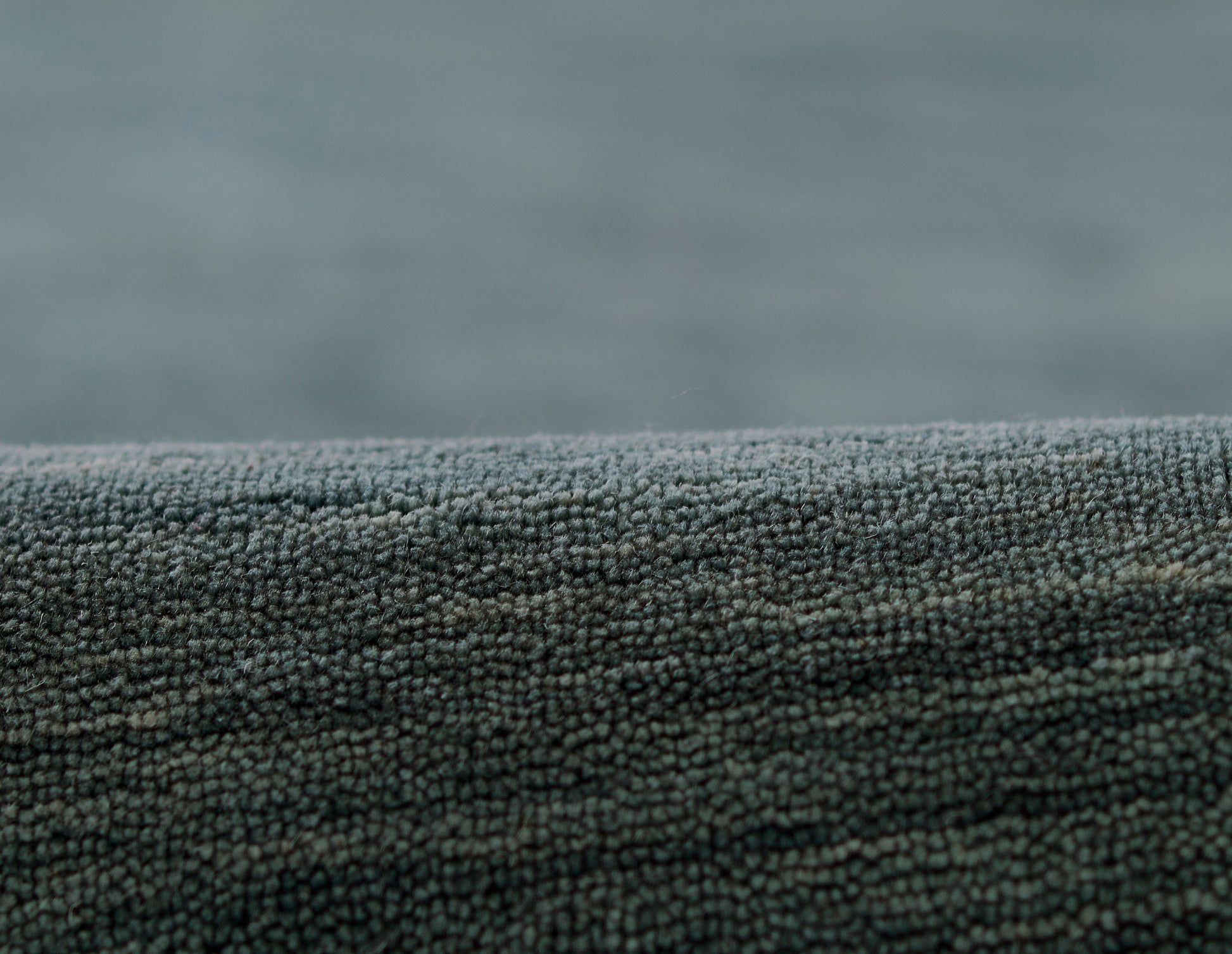 Blue-gray plush microfiber rug close-up with dense tiny loops and rolled edge