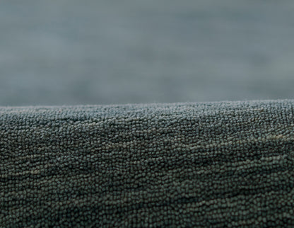 Blue-gray textured rug fabric close-up with tiny looped pile for a cozy, modern floor covering.