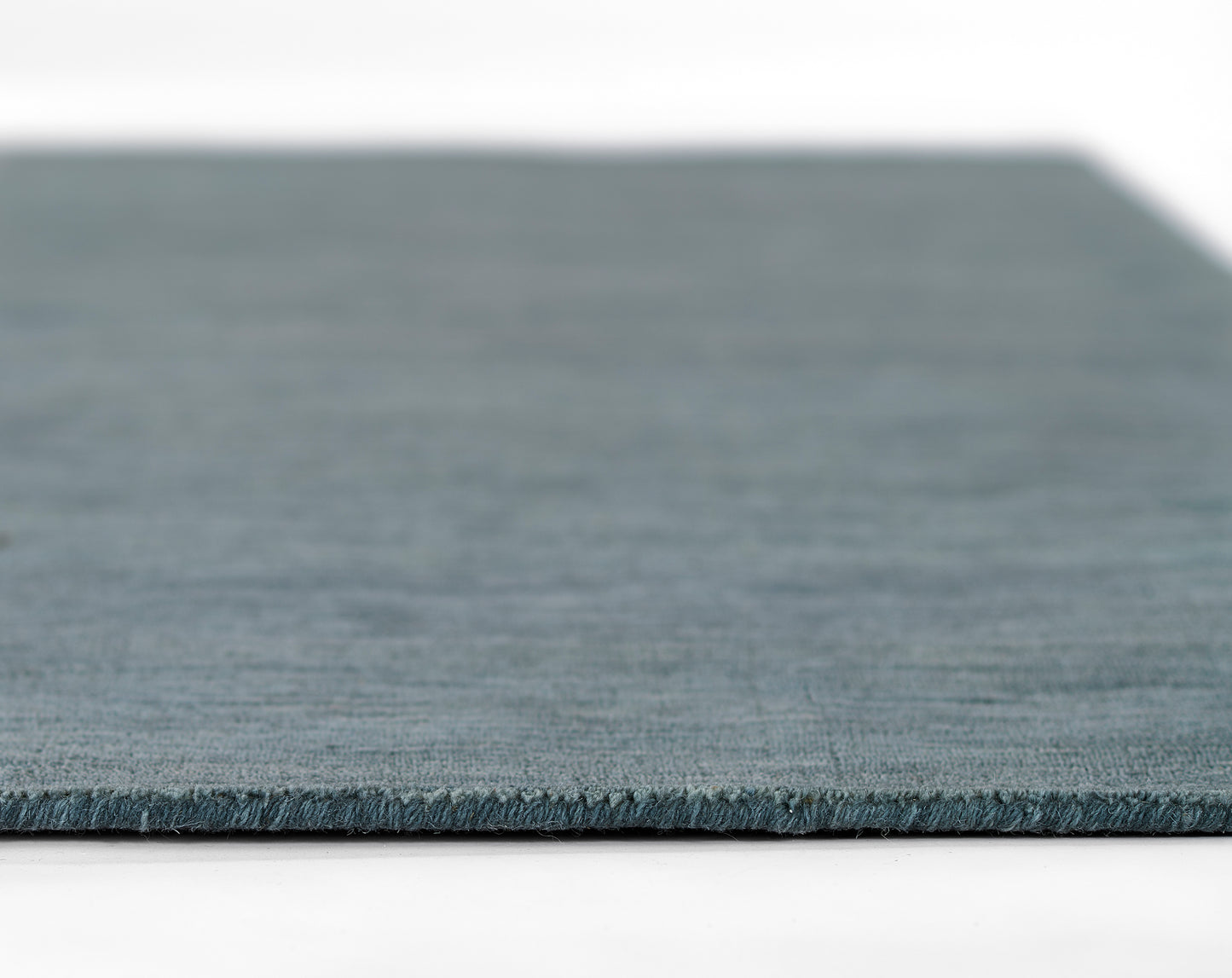 Teal-blue flatwoven rug with soft texture, rectangular shape for modern living-room decor.