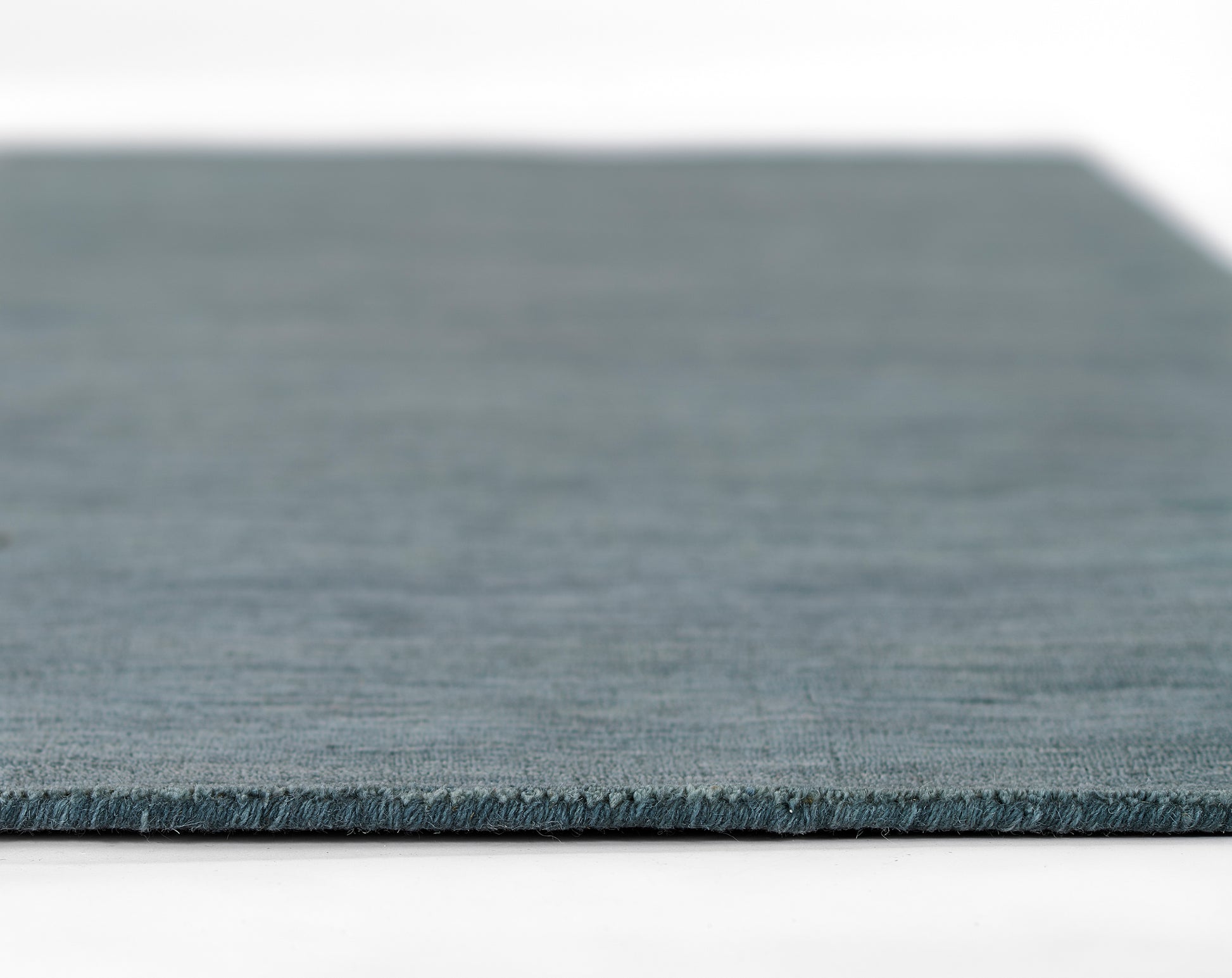 Teal-blue flatwoven rug with soft texture, rectangular shape for modern living-room decor.