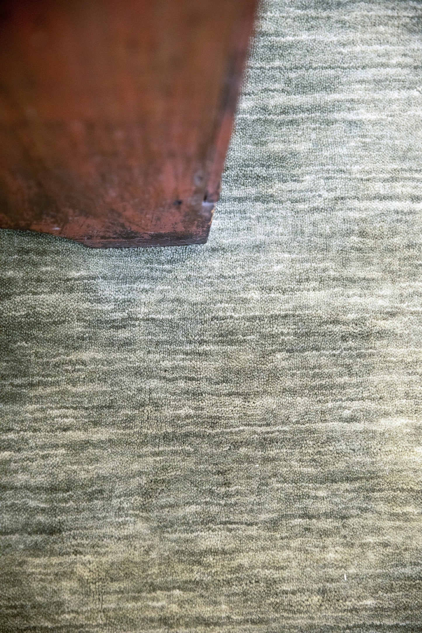 Close-up of a brown wooden edge resting on a weathered gray wooden surface; rustic furniture detail.