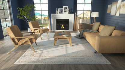 Modern living room with blue walls, beige sectional and armchairs, wooden coffee table, white fireplace, and patterned rug.