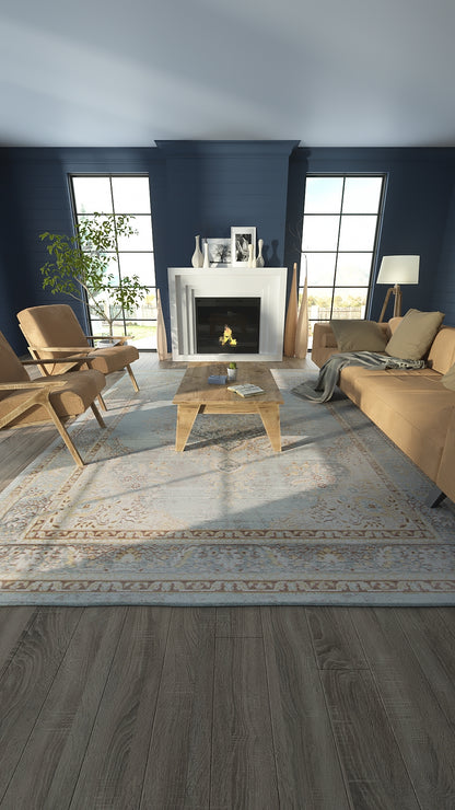 Blue-walled living room with a white mantel fireplace, tan mid-century sofas and chairs, glass-top coffee table, and a patterned rug.