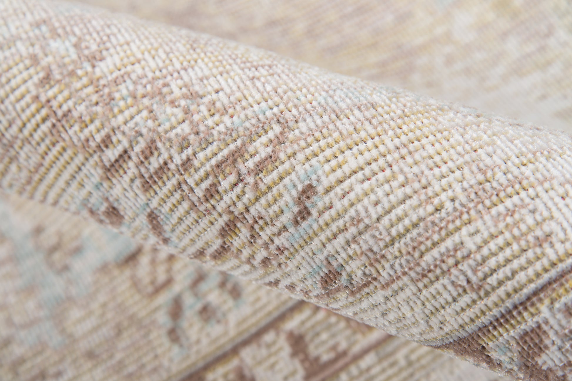 Beige and cream textured woven rug with subtle geometric pattern and pale blue and brown flecks.