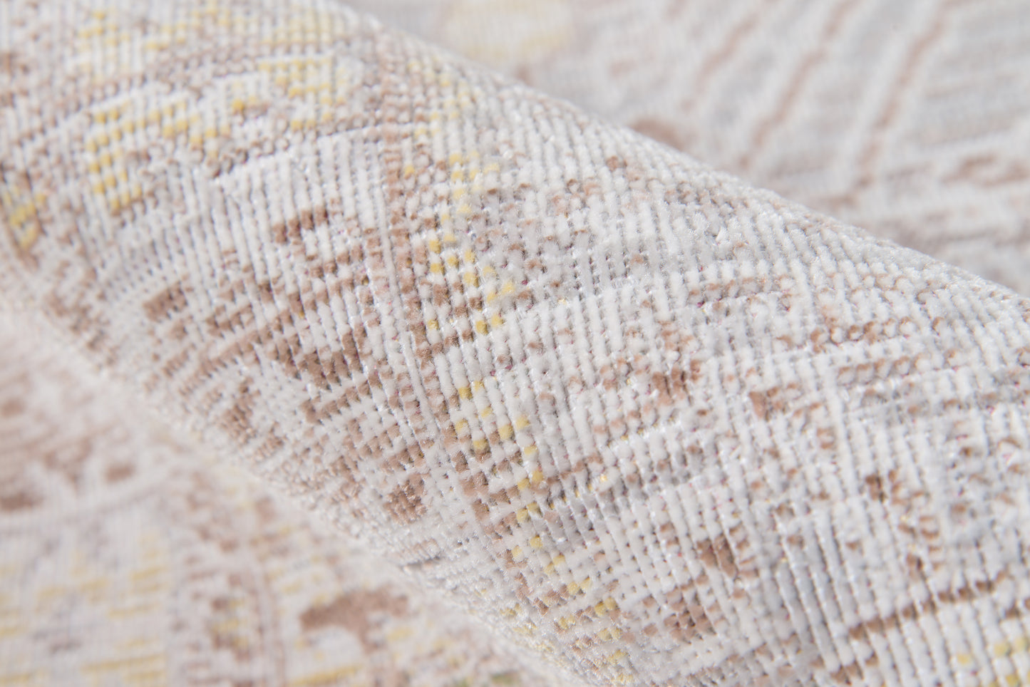 Beige-gray woven rug close-up with subtle yellow accents and geometric pattern.