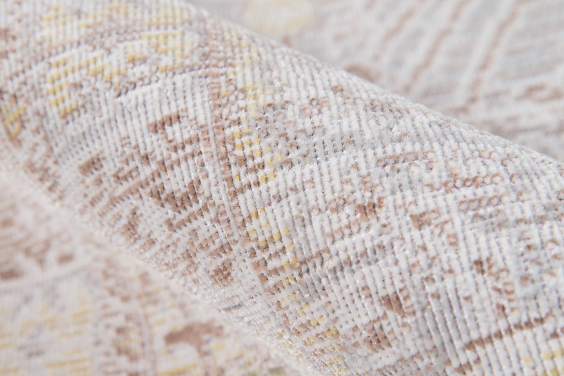 Beige-gray woven rug close-up with subtle yellow accents and geometric pattern.
