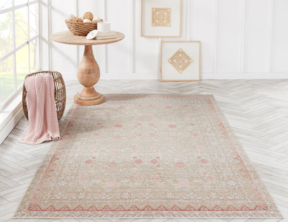Beige oriental rug with pink floral accents in a bright room; round wooden pedestal table, wicker basket, and framed art.
