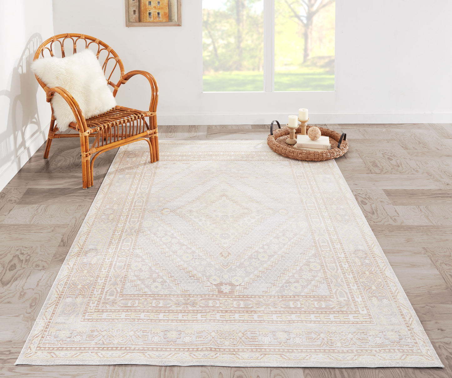 Ivory-gray oriental patterned area rug with a subtle medallion border in a bright room beside a wicker chair.