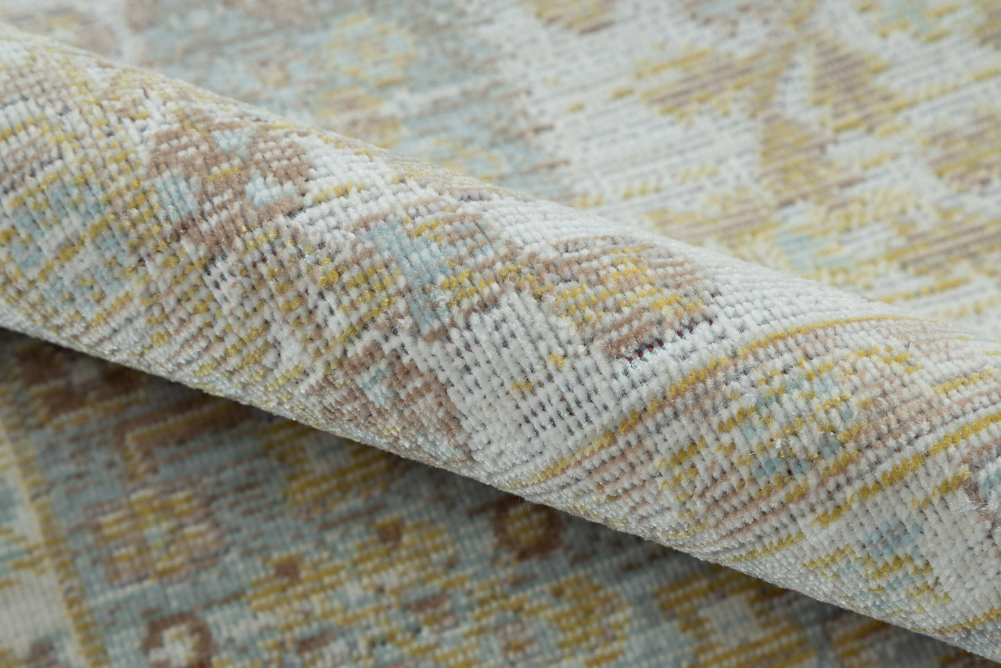 Close-up of a soft, textured woven area rug in ivory, pale blue, beige and yellow.