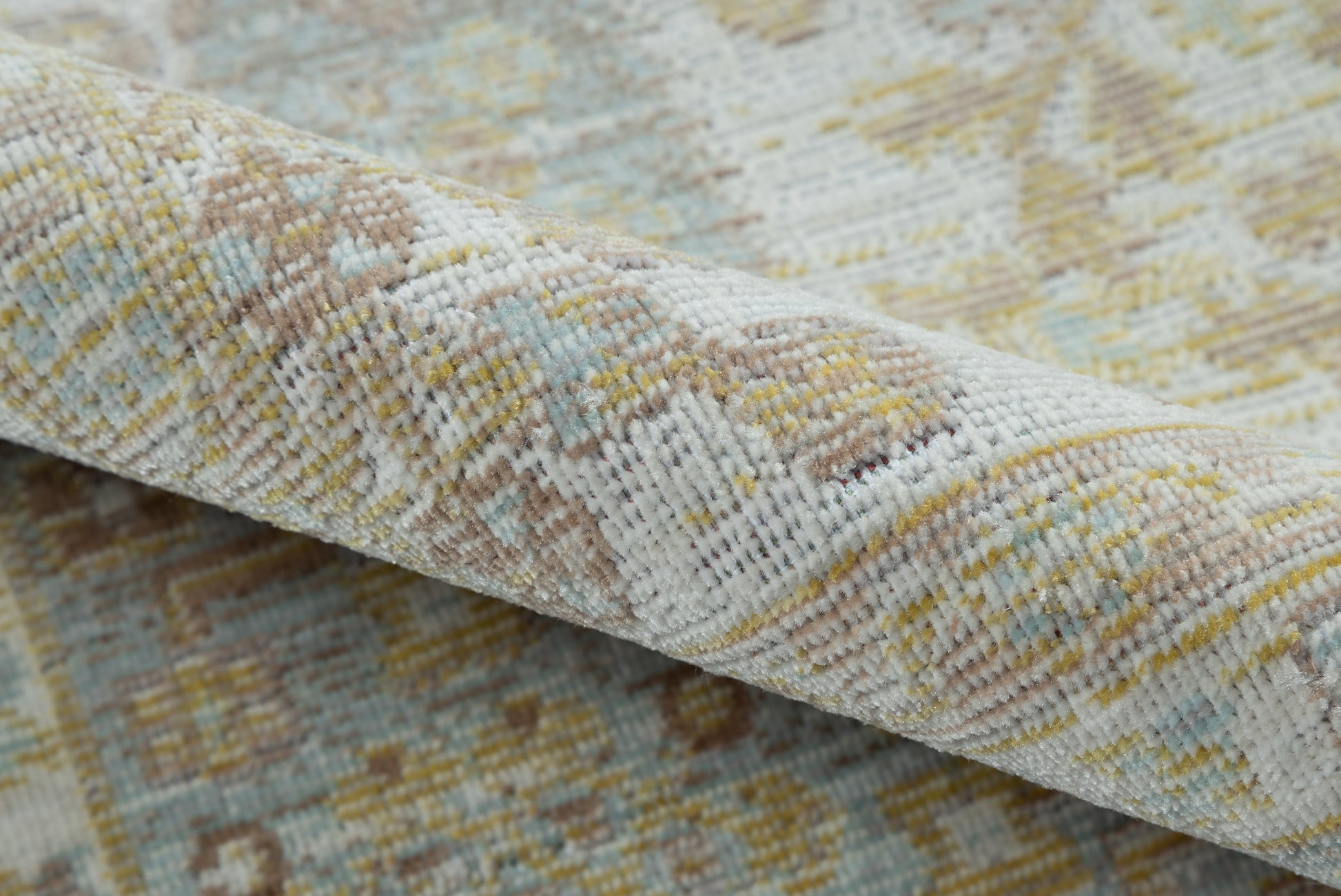 Close-up of a soft, textured woven area rug in ivory, pale blue, beige and yellow.