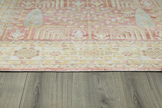 Rectangular pink oriental rug with ivory border, pale yellow highlights and blue motifs on gray wood floor.