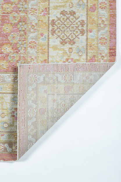 Pink and beige oriental rug with gold accents; ornate geometric motifs, folded corner reveals light beige underside.