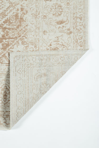 Beige-brown Oriental-style rug with faded floral pattern; woven texture, folded corner showing underside.