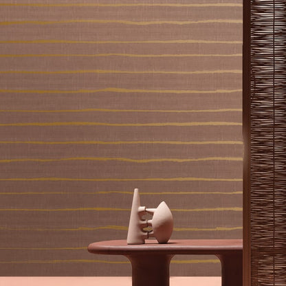 White ceramic abstract cone and orb sculpture on a brown oval table, striped wall with a woven screen.