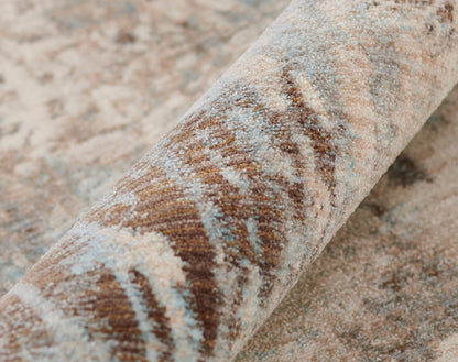 Rolled oriental-style rug in brown, beige and dusty blue with a distressed pattern and plush pile.
