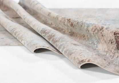 Beige and blue abstract rug with brown accents, rolled edges, soft pile and textured finish.