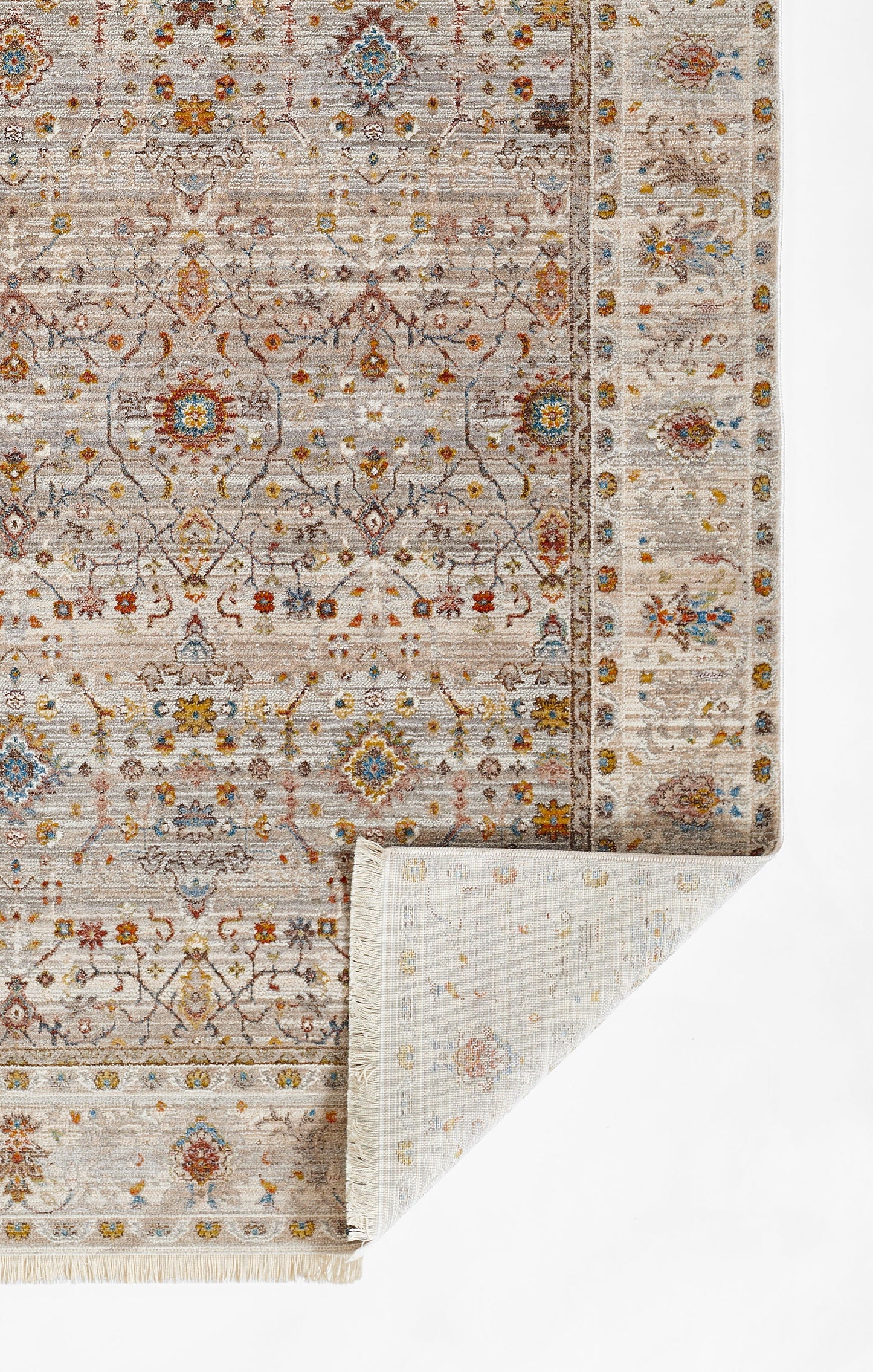 Muted beige-gray oriental rug with blue and rust floral medallions and decorative border; folded corner.