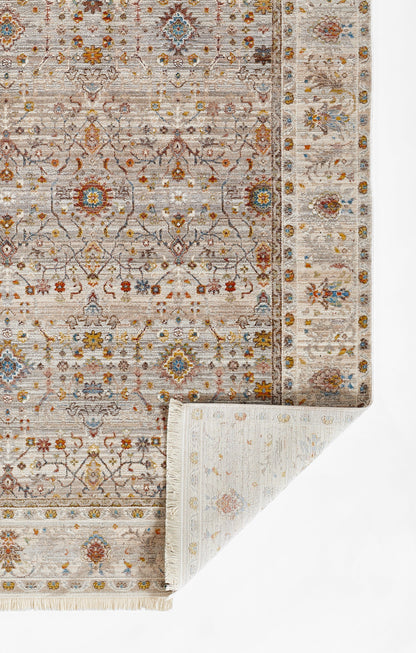 Muted beige-gray oriental rug with blue and rust floral medallions and decorative border; folded corner.