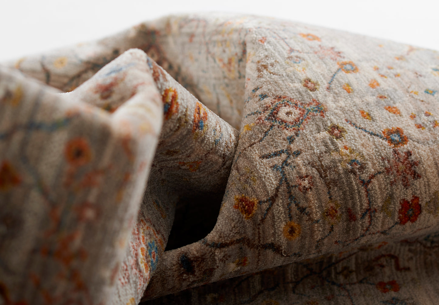 Gray floral rug with tiny orange, yellow and blue flowers; soft woven texture.