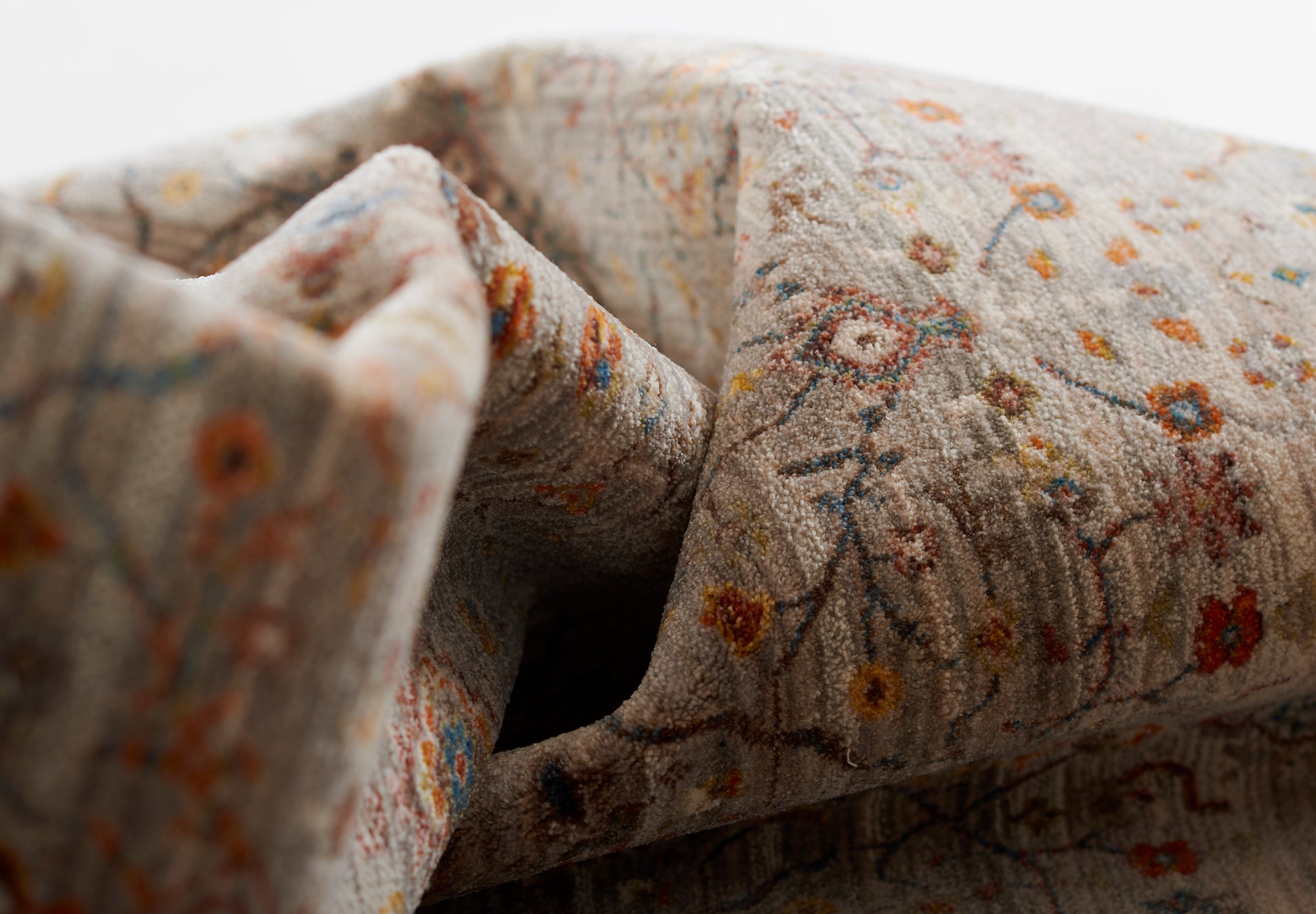 Gray floral rug with tiny orange, yellow and blue flowers; soft woven texture.