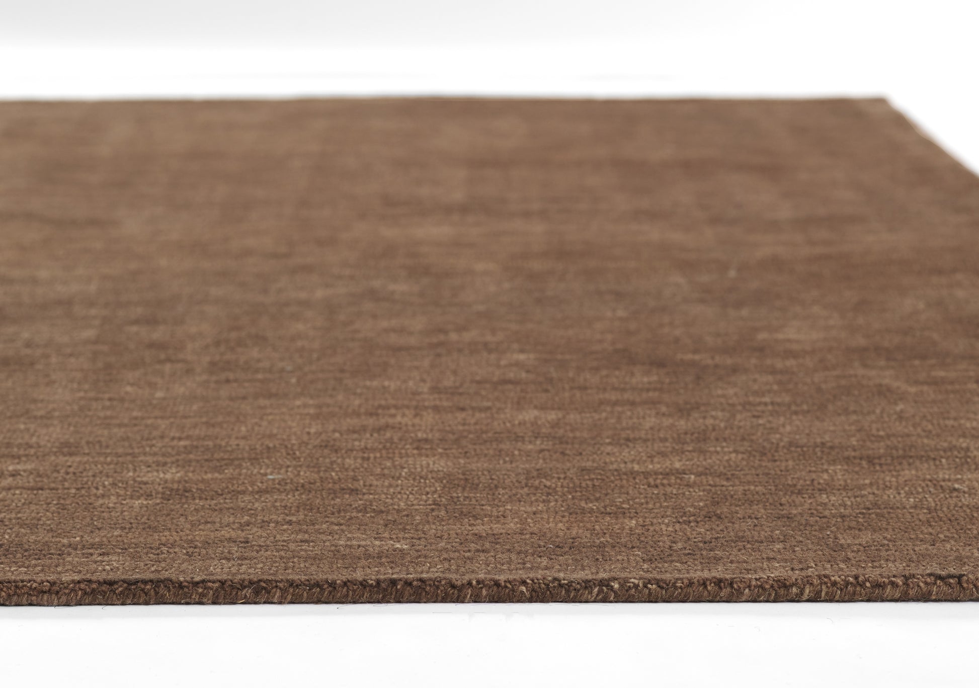 Brown textured coir rug, rectangular entry rug with rough woven fibers and natural earthy look.