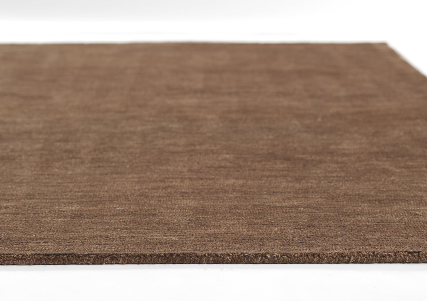 Brown natural fiber rug, flat rectangular with coarse texture and rough edge.