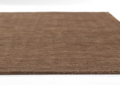 Brown natural fiber rug, flat rectangular with coarse texture and rough edge.