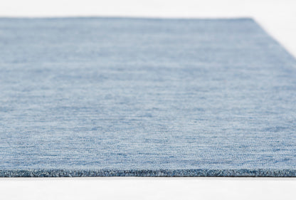 Blue textured flat-weave rug with subtle heathered tones and a bound edge.