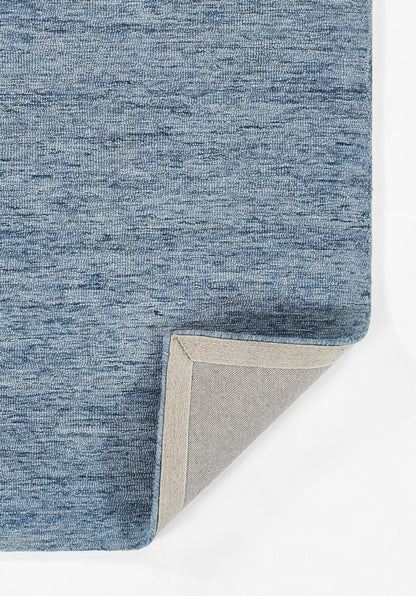 Blue heathered fabric rug with a folded corner revealing light beige backing and gray underside.