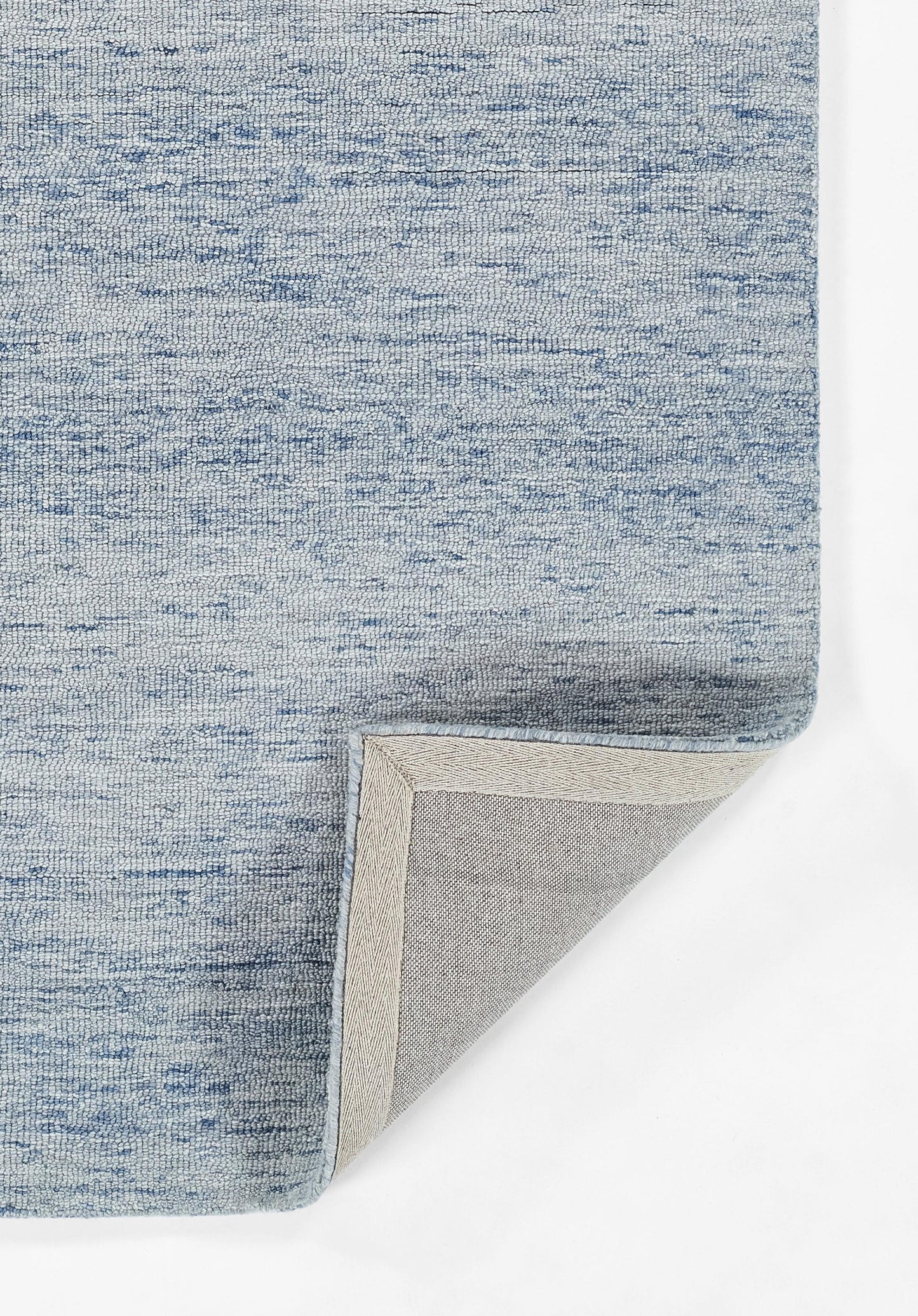 Blue heathered rug with pale beige underside; folded corner reveals backing, modern woven texture.