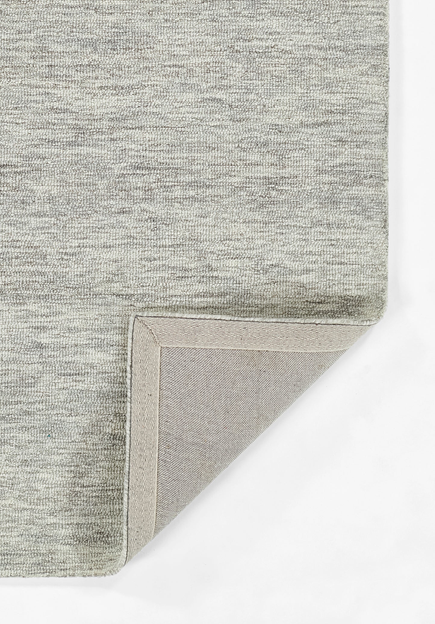 Light gray heather rug with soft woven pile; folded corner reveals beige underside