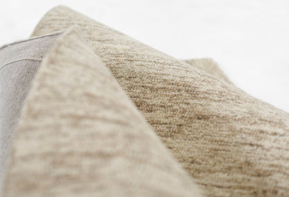 Beige and taupe textured woven fabric close-up with folded edge; natural home decor textile.