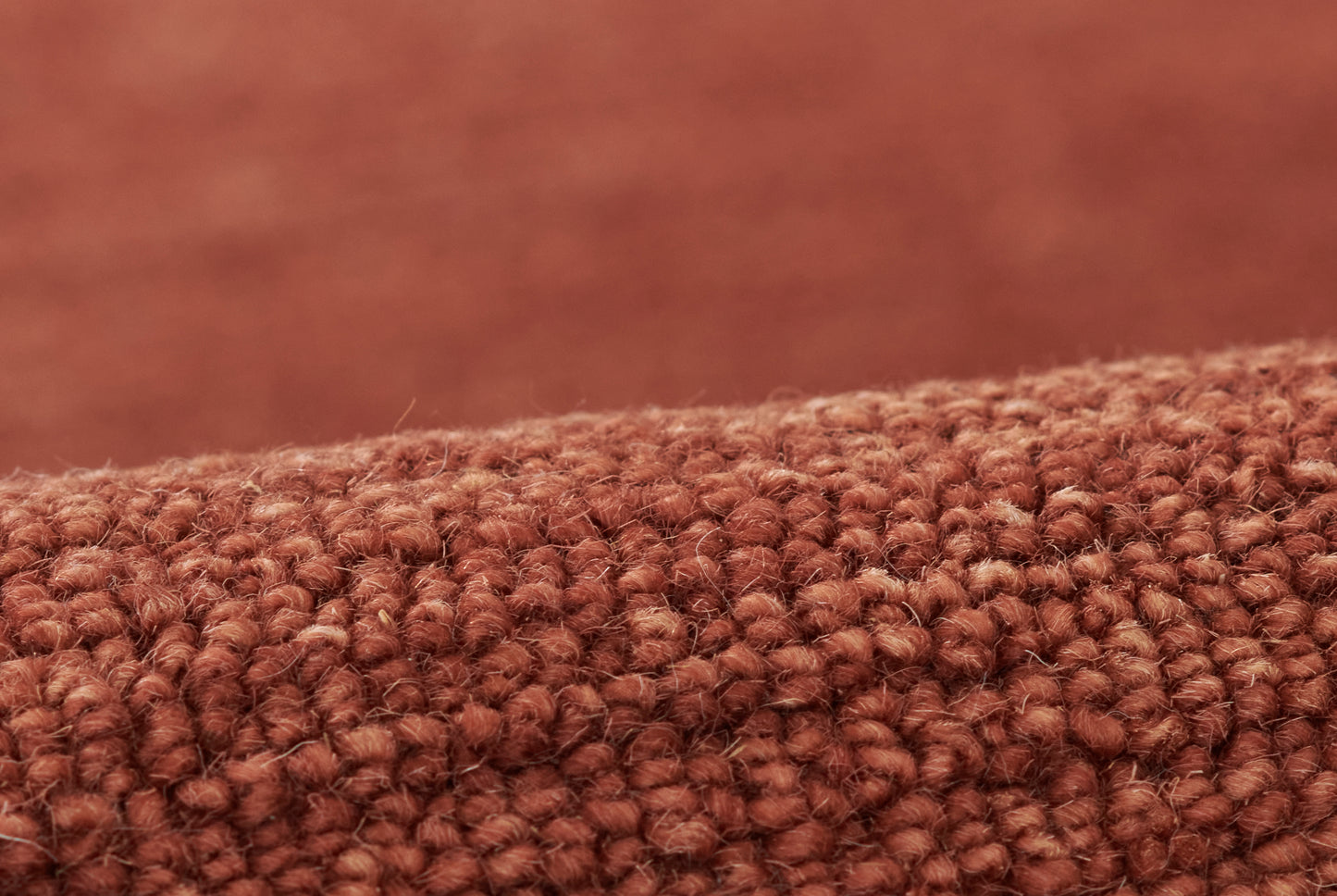 Close-up of rust-brown boucle rug with dense loop pile.
