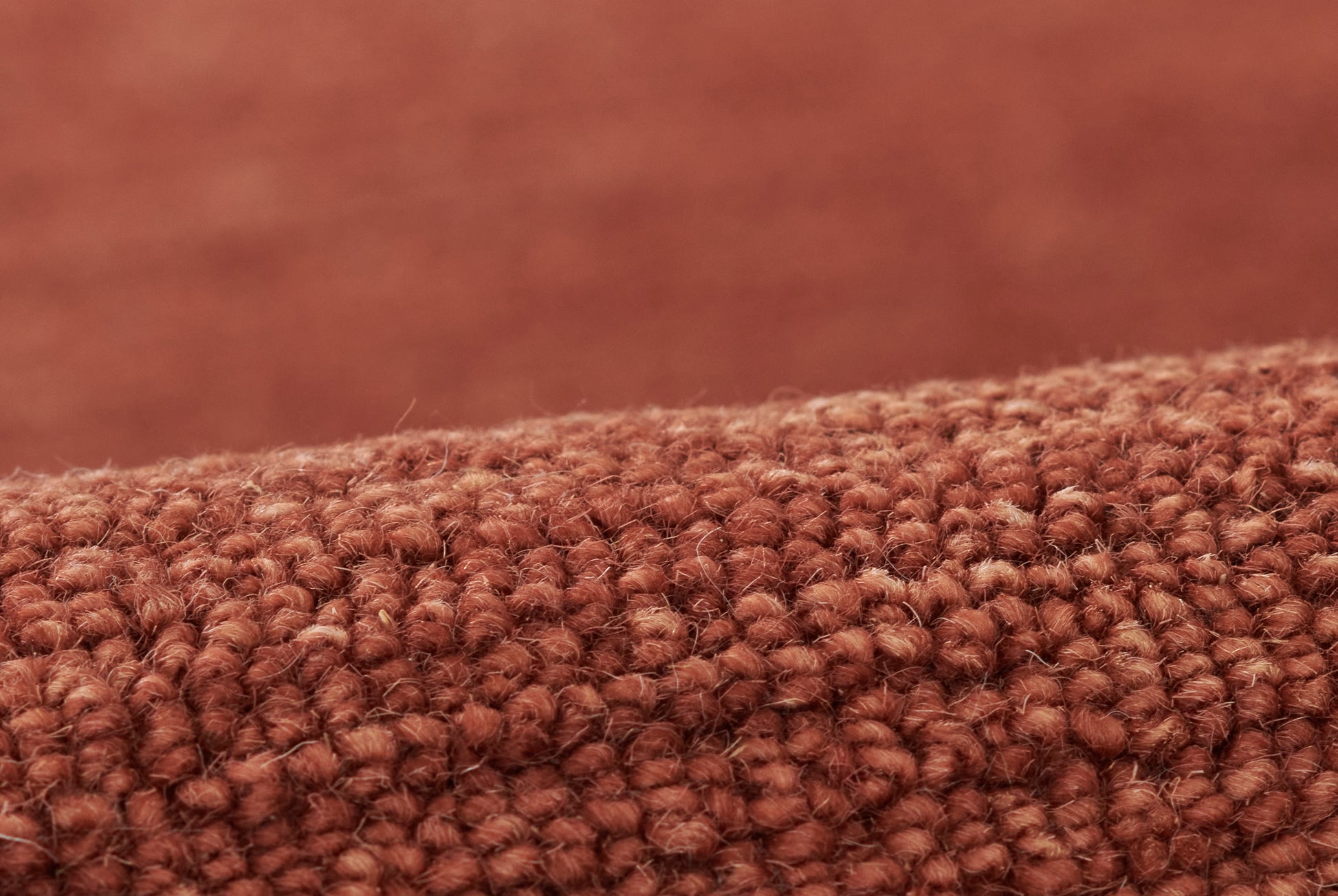 Close-up of rust-brown boucle rug with dense loop pile.