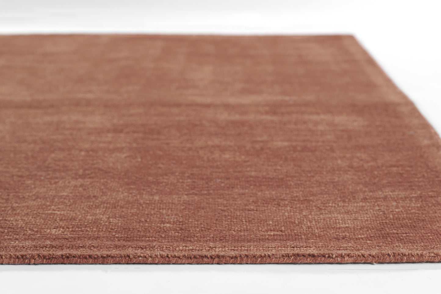Brown textured rug with short pile in a terracotta tone, rectangular rug.