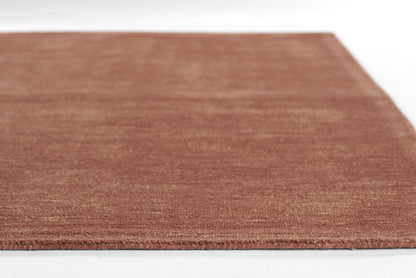Brown textured rug with short pile in a terracotta tone, rectangular rug.