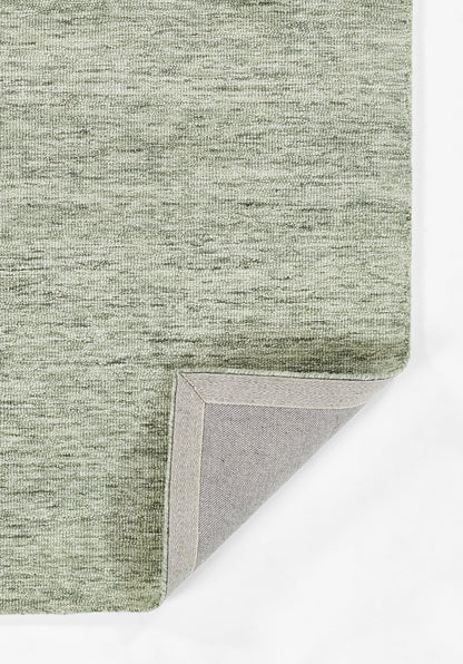 Sage green textured rug with a heathered weave and light gray backing visible at the folded corner.