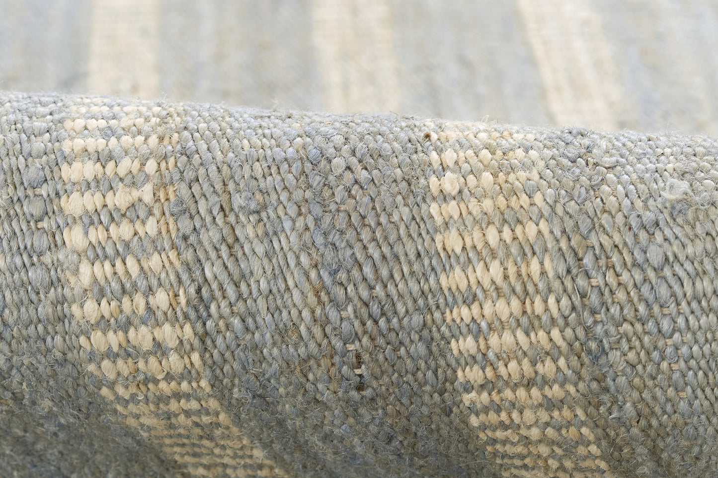 Blue-gray woven textile with beige stripes, close-up of textured rug.