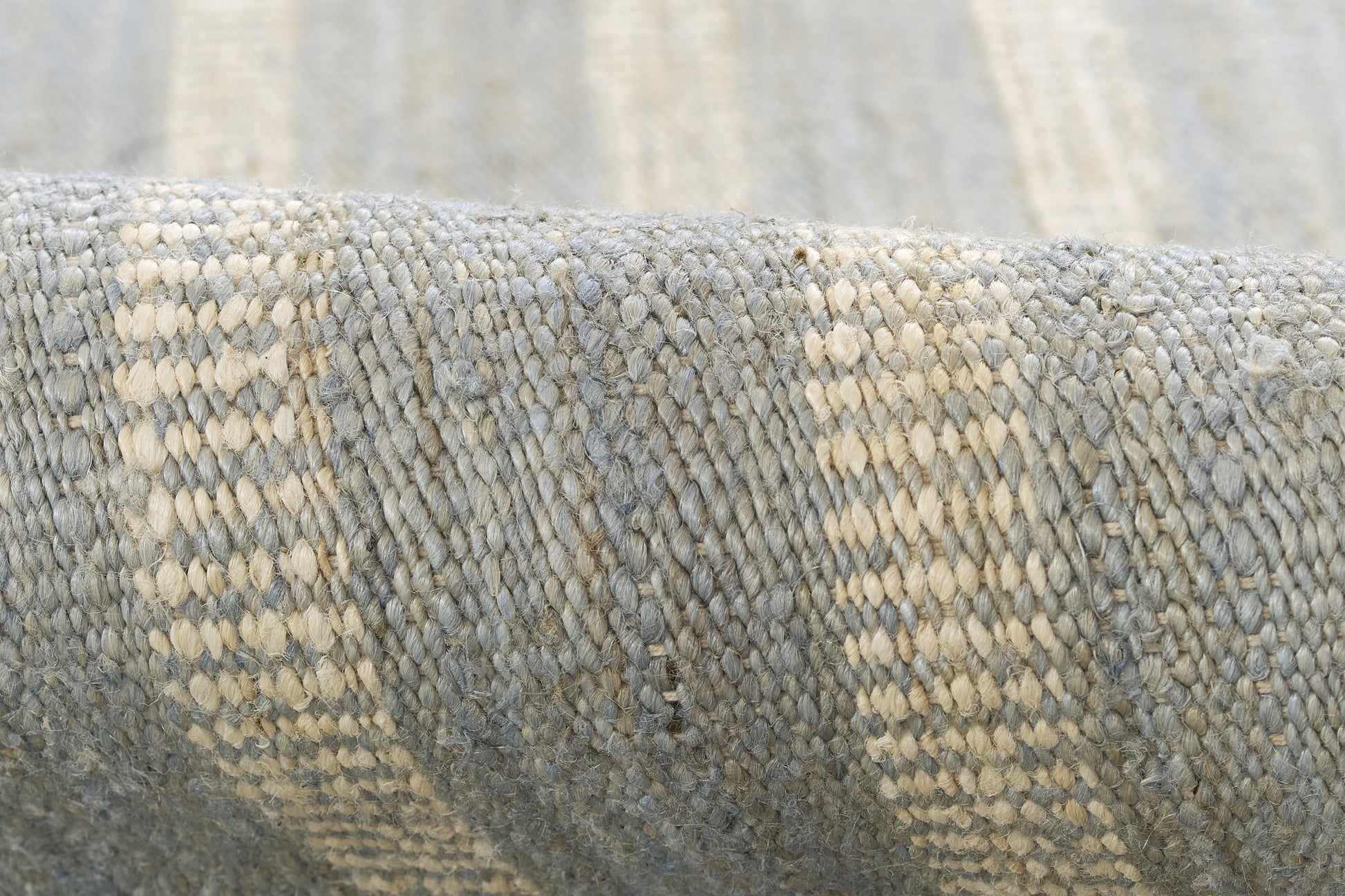Blue-gray woven textile with beige stripes, close-up of textured rug.