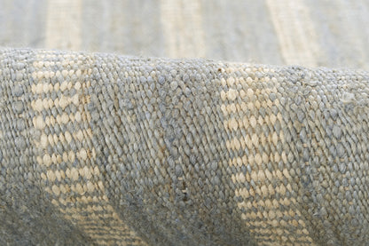Blue-gray woven textile with beige stripes, close-up of textured rug.