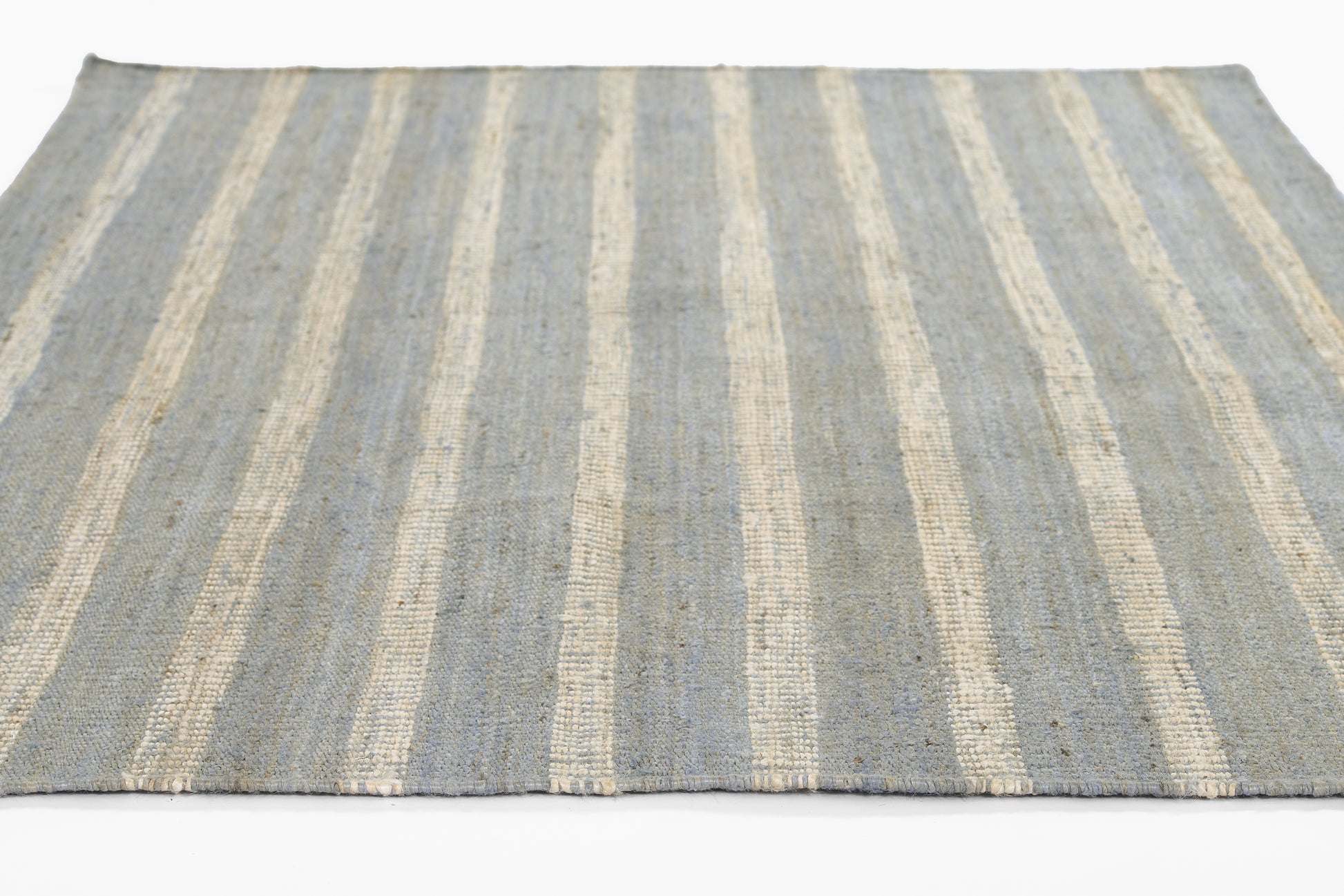 Rectangular textured flat-weave rug with blue & ivory stripes, casual coastal style.