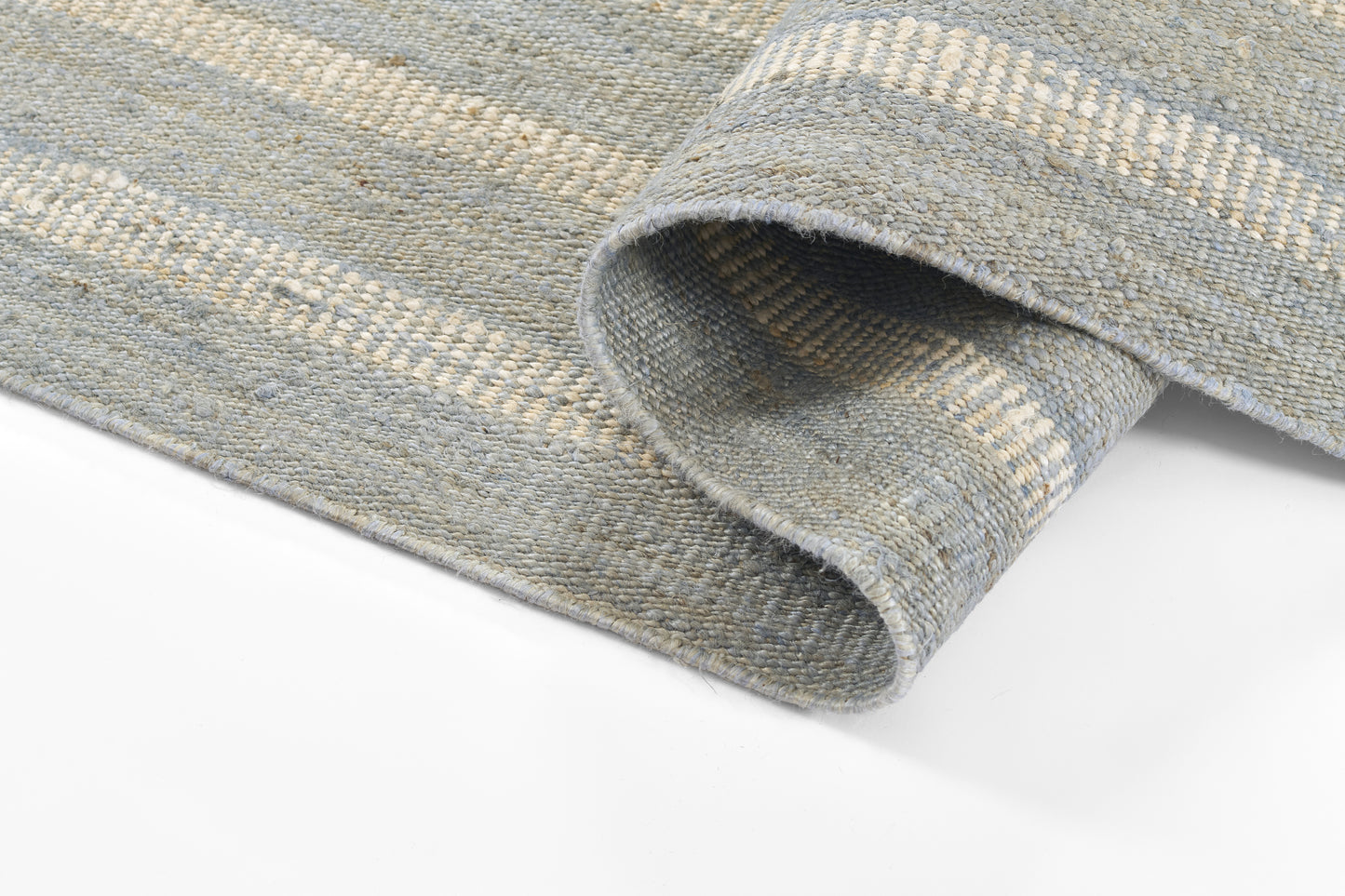 Blue-gray striped woven rug with thick textured weave, rolled edge visible; versatile for living room or bedroom.