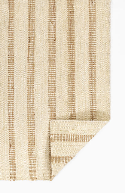 Beige woven rug with vertical brown stripes; natural fiber, folded corner.