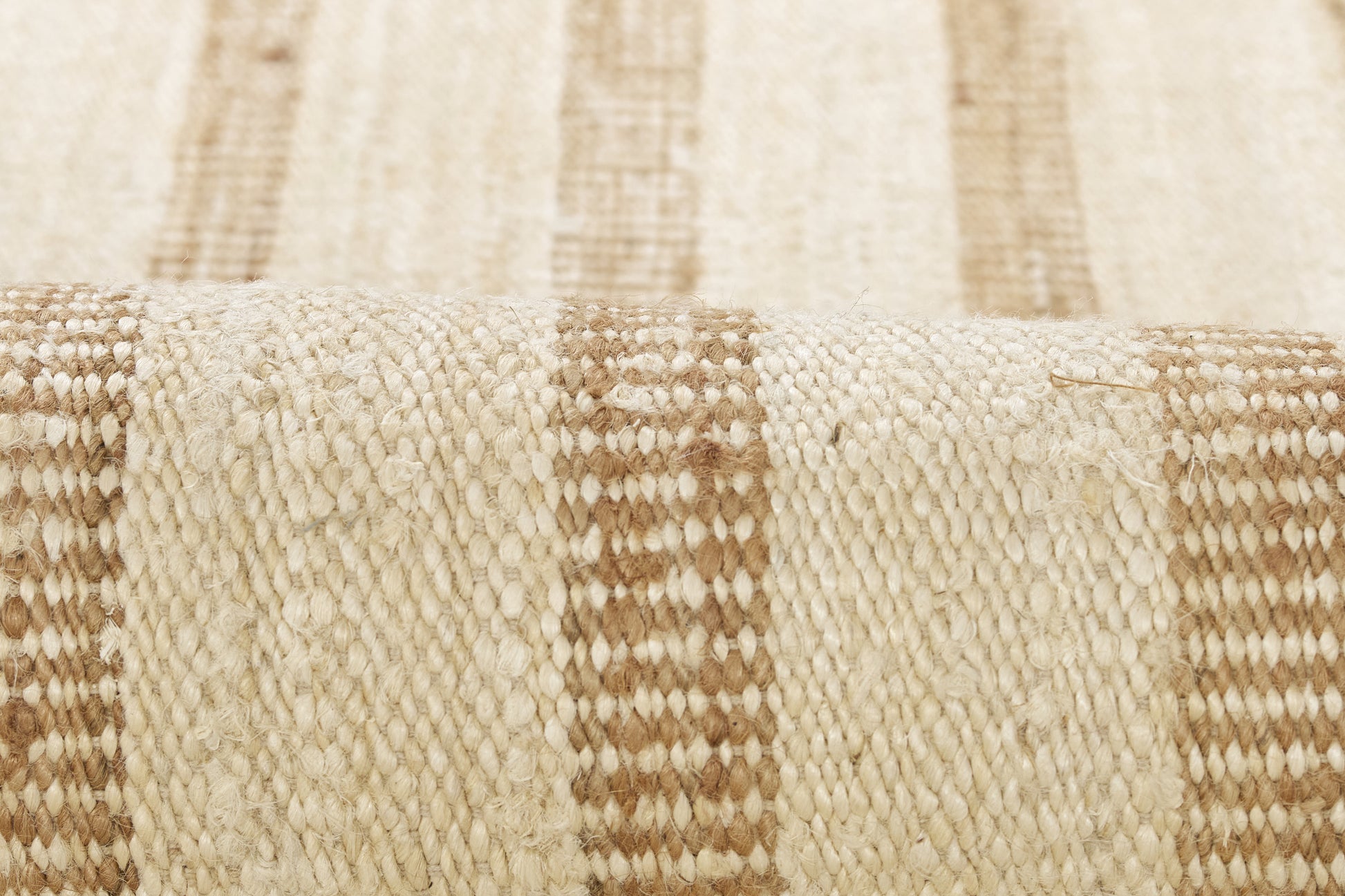 Beige and brown striped woven rug with natural fiber texture; close-up view.