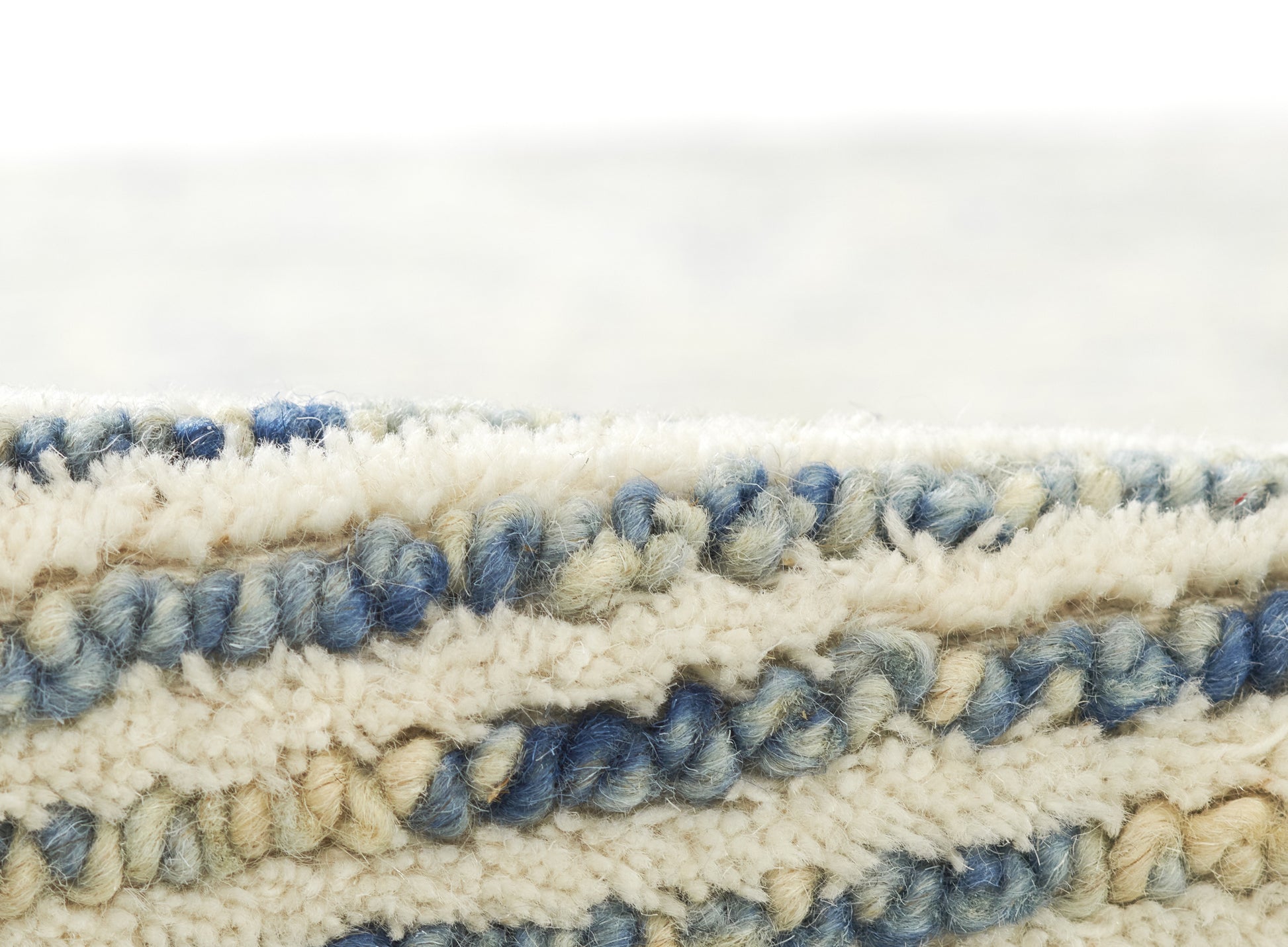 Blue and cream boucle rug with chunky looped pile and striped pattern, soft textured coastal style.