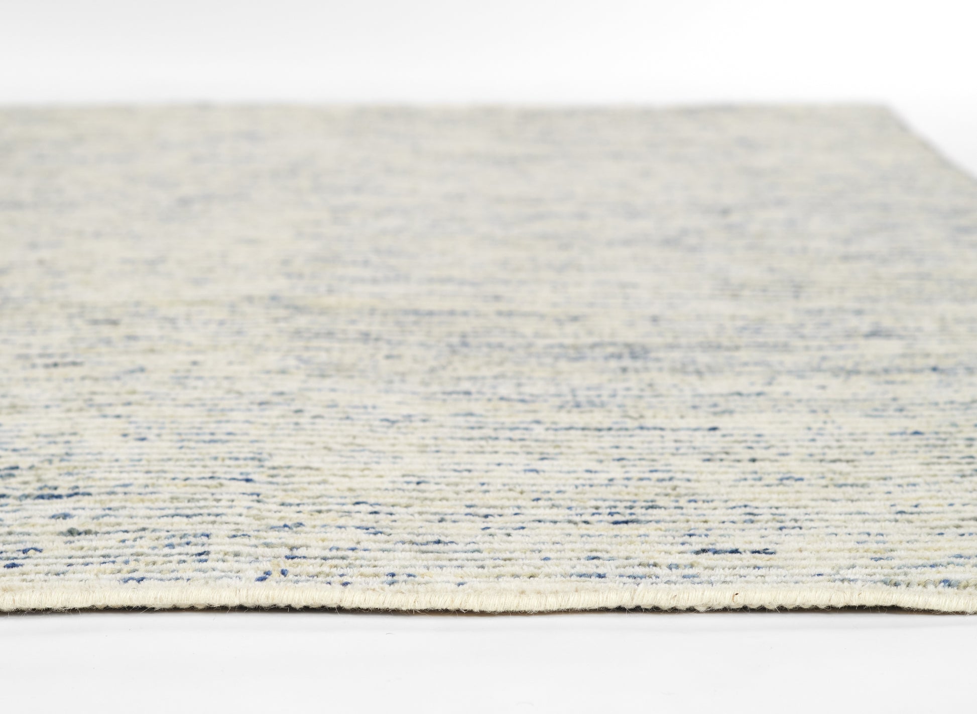 Beige rug with blue speckled pattern, low-pile flat-weave style for neutral living spaces.