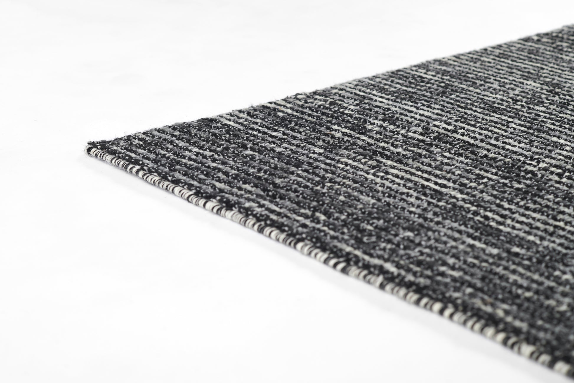 Charcoal gray woven rug with a textured surface and striped edge binding, 2' x 3'.