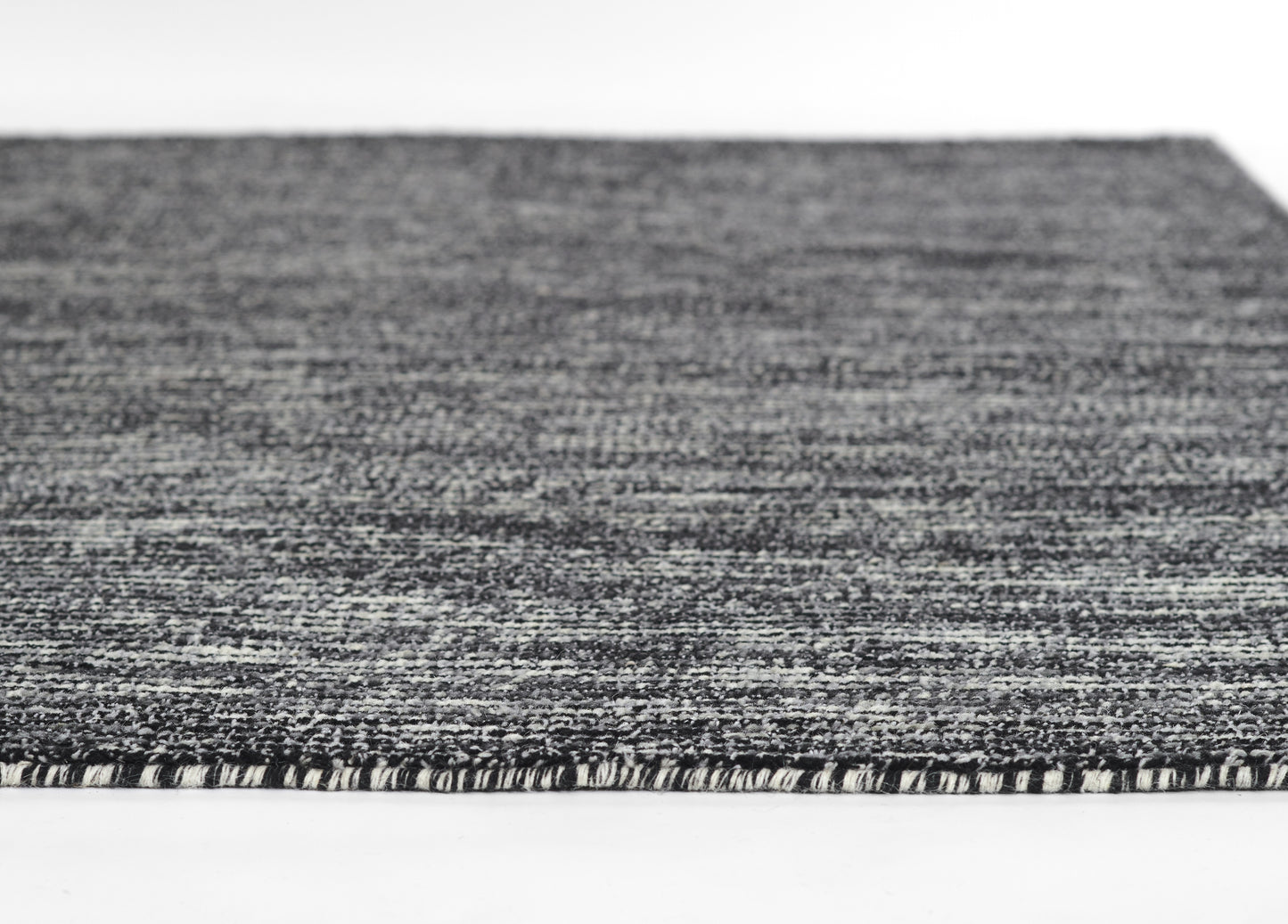 Close-up of a gray marled woven rug with short fringe edge, modern flat-weave style.